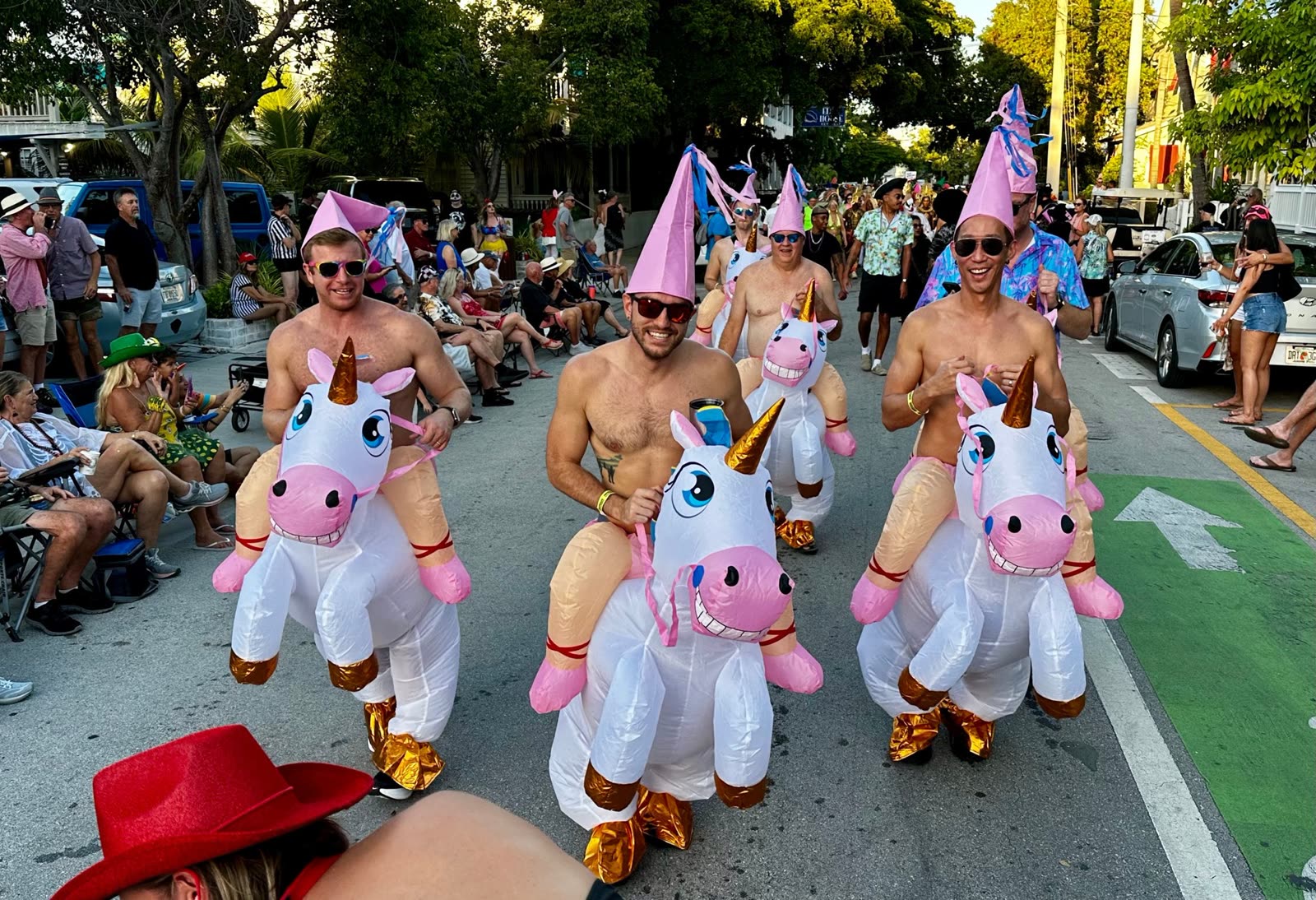 Men in inflatable unicorn costumes and party hats on a Key West street