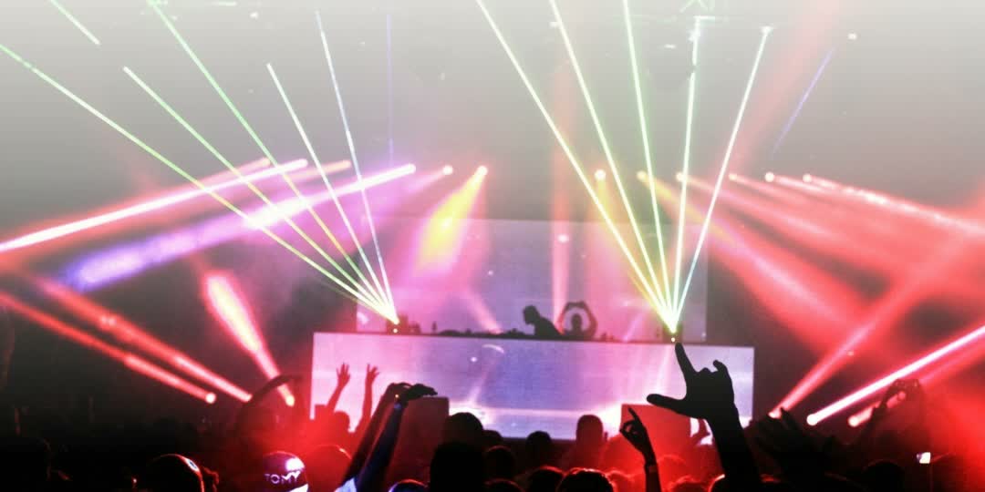 Lasers over a packed dance floor at a queer dance party